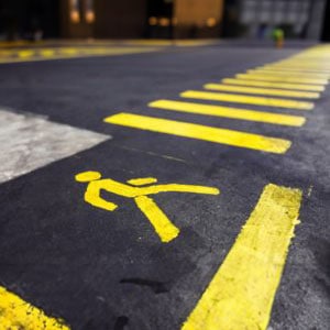 A yellow pedestrian crossing sign on a road - Levian Law