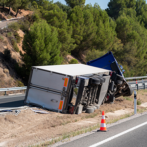 Truck with an accident refrigerated semi-trailer, overturned by the exit of the highway in the median of the highway.